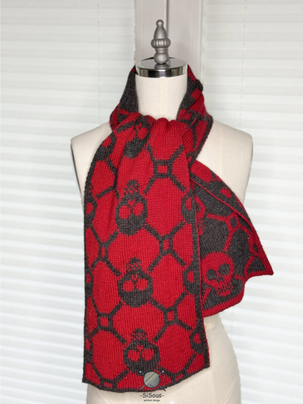 sisous-patternderndesign-skull-schal-9 Totentanz-Schal in Double Knitting, locker um den Hals gelegt getragen, rote Vorderseite mit Blick auf anthrazitfarbenen Enden-Totenkopf